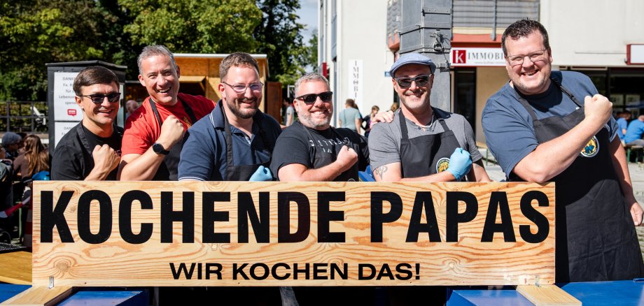 Männer hinter einem Schild
