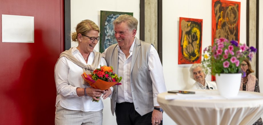 Frau gratuliert Mann zur Vernissage