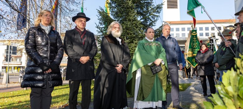 Menschen gedenken am Kriegerdenkmal