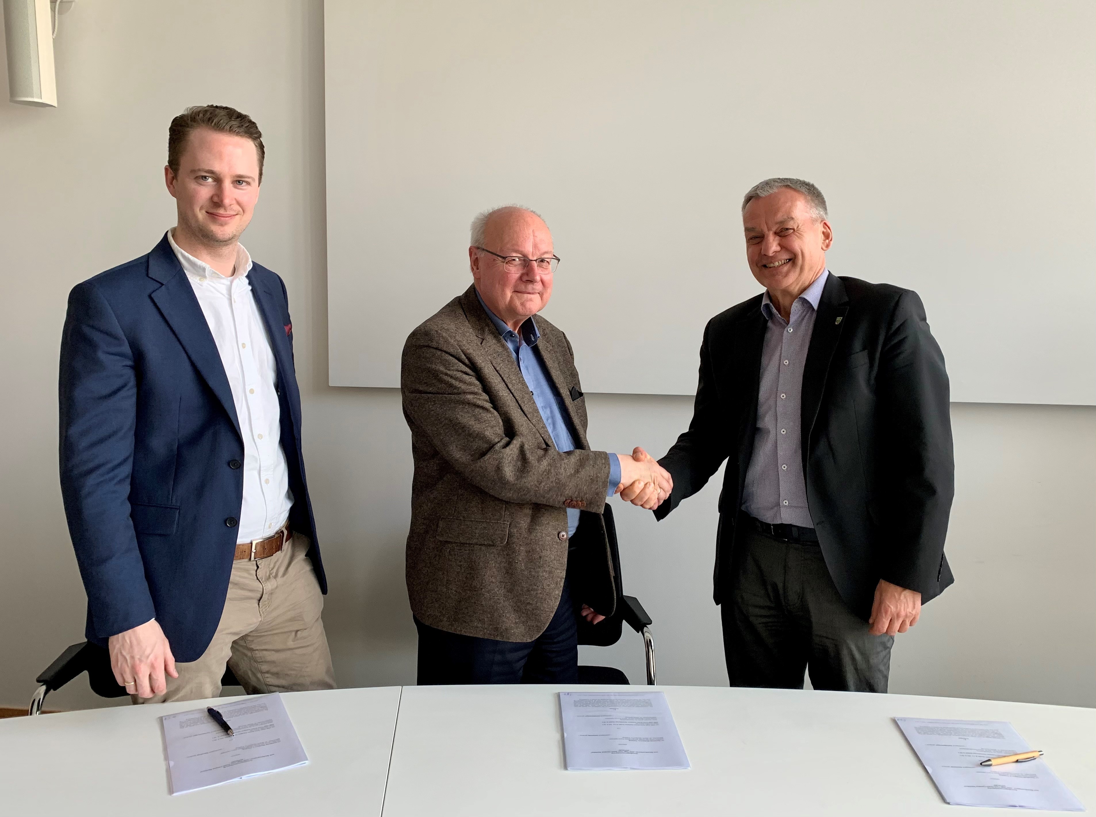 drei Männer und zwei schütteln Hände