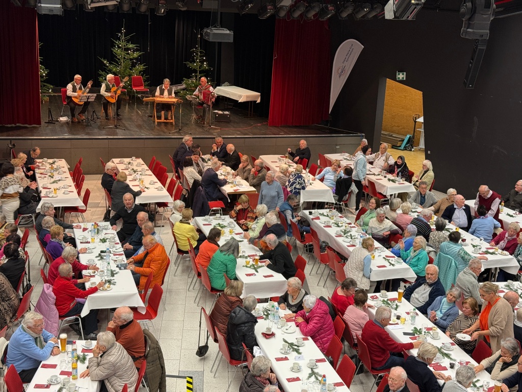 viele Menschen an gedeckten Tischen